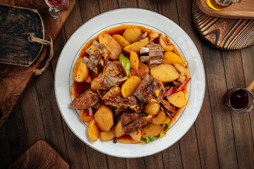 Uzbek dish kazan kabob with lamb and potatoes on a wooden background