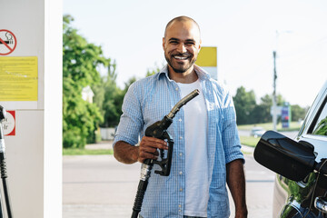 Man filling gasoline fuel in car at gas station