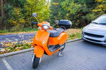 a scooter on an autumn day, against the background of the park