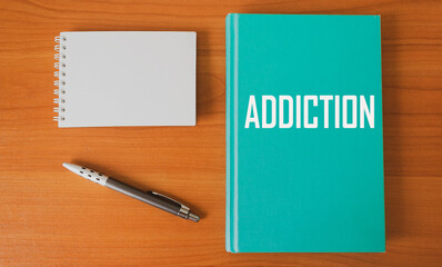 Diary with the inscription Addiction on the table with a pen and notepad for writing
