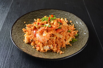 thai style spicy chilli tom yum dry fried egg rice with seafood prawn and meat in black background asian halal menu