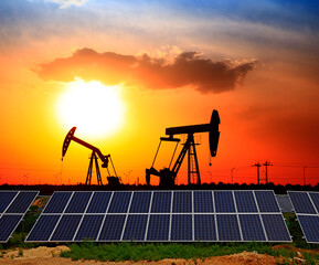 Oil pump with solar panels and the sunset