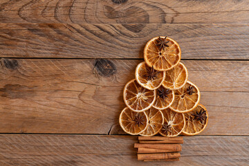 Christmas tree made of dried oranges, cinnamon and anise. Viewed from above. Concept of christmas holiday greeting card. Copy space for text