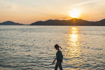 夕暮れの海にいる女性