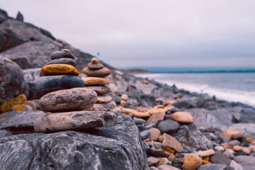 Fototapeta na wymiar Pyramid of stones by the ocean at blue hour