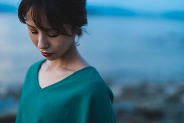 夕暮れの海にいる女性