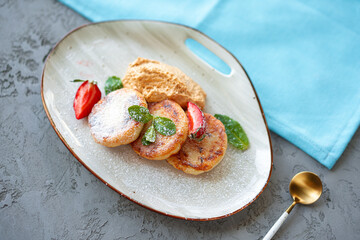 Cottage cheese pancakes with strawberry and sugar powder