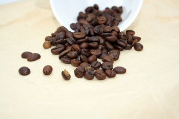 Grains of fragrant fresh coffee on craft paper.