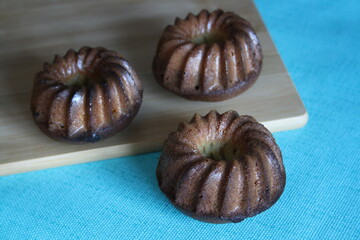 A small shaped cupcake on a wooden board.