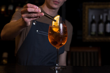 The bartender making Aperol Spritz cocktail. Bartender hands close up