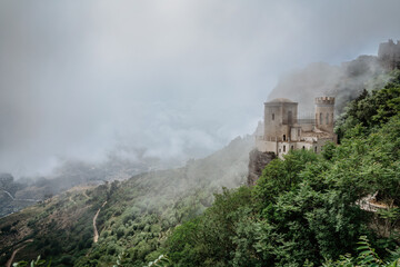Erice,Sicily,Italy.Historic town on the top of mountains overlooking beautiful lush countryside.View of Venus Castle,Castello di Venere, in clouds.Breathtaking panorama.Misty landscape copy space