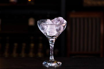 Glass with ice cubes on the bar