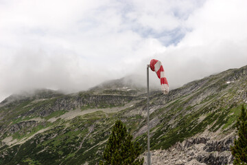 Red and white wind cone with mountains in the background