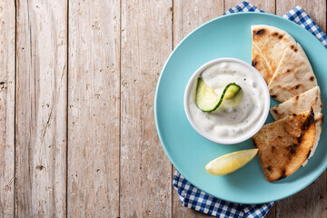 Traditional Greek Tzatziki on wooden table. Top view. Copy space
