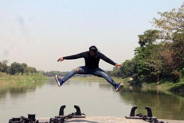 Handsome carefree young delightful guy with black hair is jumping up