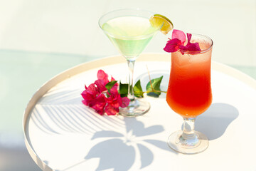 Refreshing summer cocktails in the beach club near the pool. Relaxed atmosphere of vacations, fun, happiness. Luxury lifestyle. Bright colors, hard light and shadows. Close up