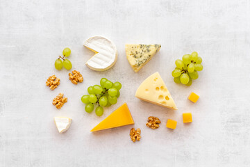 Fototapeta na wymiar Set of different types of cheese with grapes. Dairy products flat lay