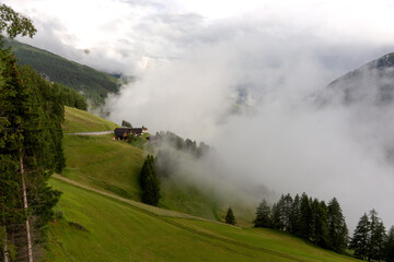 Fototapeta na wymiar Traditional alpine village houses on the misty hills. Austria