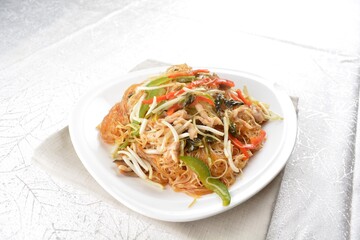 wok fried bee hoon vermicelli thin noodle with seafood and vegetables in chef dark soy sauce in white background asian halal menu