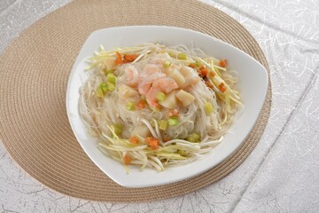 braised wok fried bee hoon vermicelli thin noodle with seafood prawn scallop and vegetables in chef white sauce in white background asian halal menu