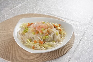 braised wok fried bee hoon vermicelli thin noodle with seafood prawn scallop and vegetables in chef white sauce in white background asian halal menu