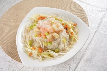 braised wok fried bee hoon vermicelli thin noodle with seafood prawn scallop and vegetables in chef white sauce in white background asian halal menu