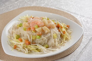 braised wok fried bee hoon vermicelli thin noodle with seafood prawn scallop and vegetables in chef white sauce in white background asian halal menu