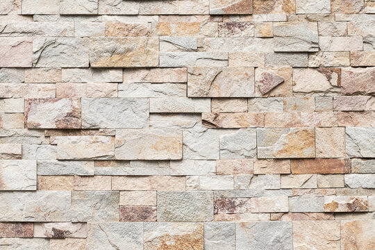 Old brick wall texture, abstract stone background. Urban brickwall, uneven rough stonewall. Beige tile, granite.
