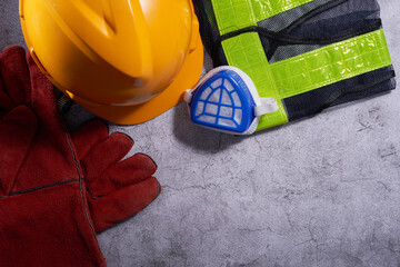 Protective workwear on cement background. Safety equipment