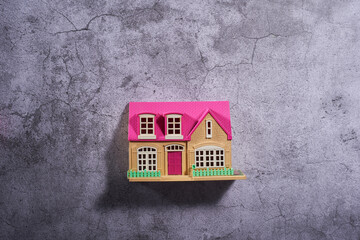 toy house with pink roof top on cement background