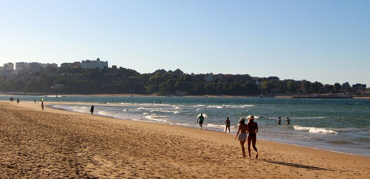 People walking on the beach of Somo on a sunny windy afternoon Santander Cantabria