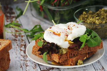 Homemade sandwiches with pesto, green salad and poached eggs