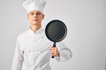 a man in a cook's uniform with a frying pan in his hands cooking work