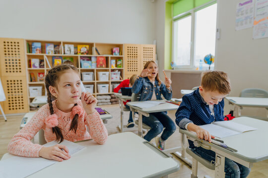Pupils wearing casual clothes solving exercise in the classroom