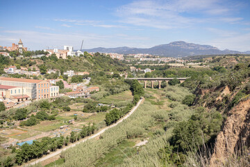 Obraz na płótnie Canvas River Park of the river Ripoll (Parc Fluvial del riu Ripoll) in Sabadell, Catalonia, Spain (Aerial View). Pont de la Salut Brige, La Mola Mountain and Torre de l'Aigua can be seen.
