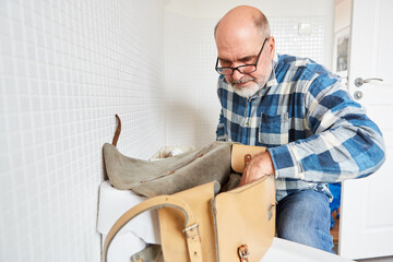 Installer repairing a defective cistern