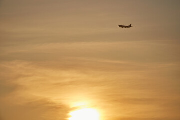 夏の夕焼けの空と飛んでいる飛行機の風景