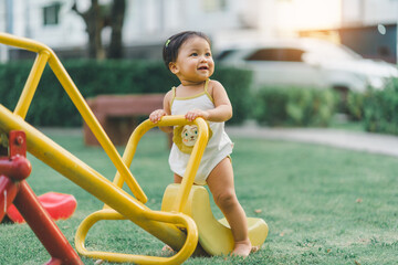 baby girl in the garden in happy and smile with relax time in playground for balanced development