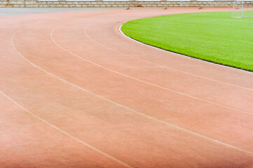 Red running track around the football field at the stadium.