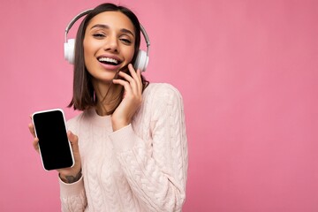 Sexy beautiful cute young brunette woman wearing pink sweater isolated over pink background wall...