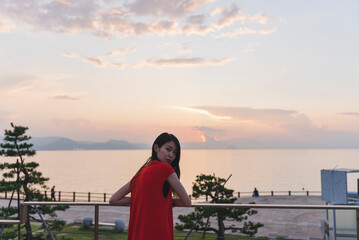 Fototapeta premium 夕暮れの海にいる女性