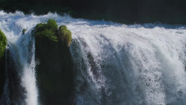 Close up of a natural waterfall with fresh river water flowing in a forest. A large and powerful cataract with a strong current. Cascata delle Marmore (Marmore Falls) in Umbria, Italy. 4K.