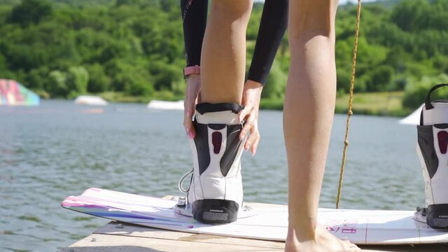 Close-up view of athletic woman taking of wakeboarding boots 
