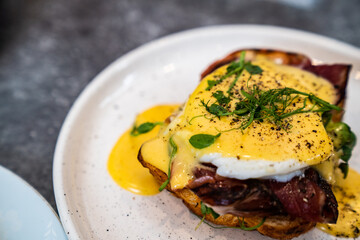 Sandwich with bacon, egg and herbs on a plate
