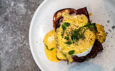 Sandwich with bacon, egg and herbs on a plate. Top view