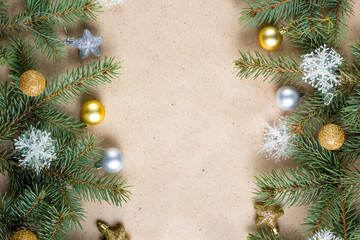 border of fir tree branch with gold decoration on craft paper for christmas card with copy space for text.