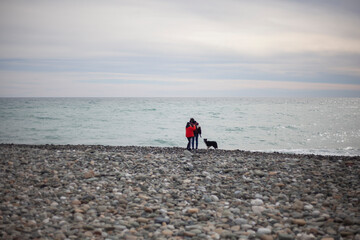 Cold weather at sea. People walk along the coast.