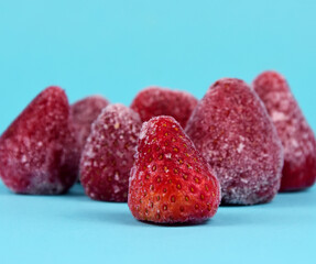 Frozen red strawberries on a blue background stock images. Pile of frozen strawberries on a blue background with copy space for text stock photo