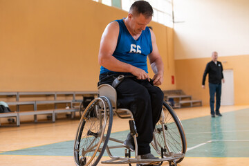Fototapeta na wymiar a handicapped basketball player prepares for a match while sitting in a wheelchair.preparations for a professional basketball match. the concept of disability sport