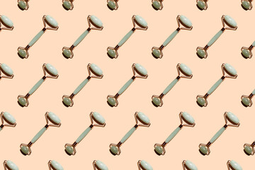 Roller massagers made of jade and rose quartz and a gua sha scraper against a background of stones are modern tools for skin care. Pattern for the beauty industry